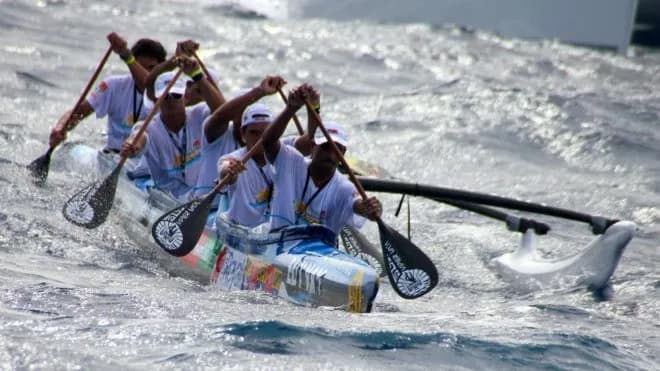 Equipe de remadores sincronizados em corrida de canoa polinésia outrigger, exemplo de trabalho em equipe no esporte