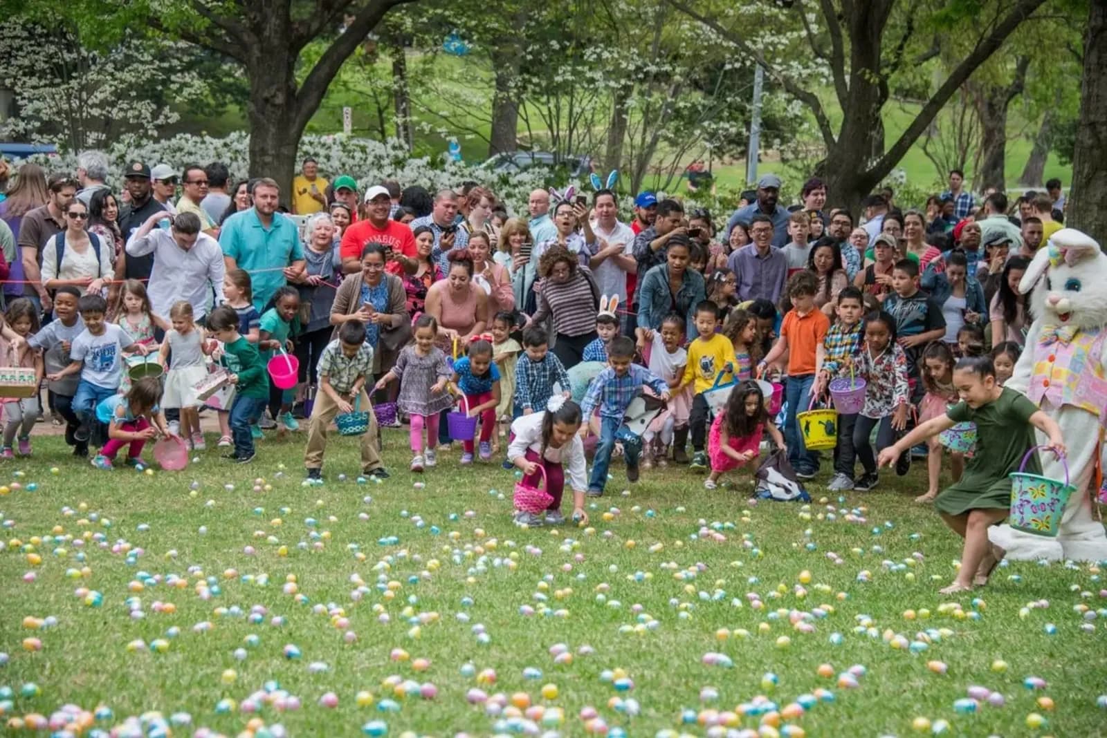 Crianças em uma grande caça aos ovos de Páscoa ao ar livre, com milhares de participantes