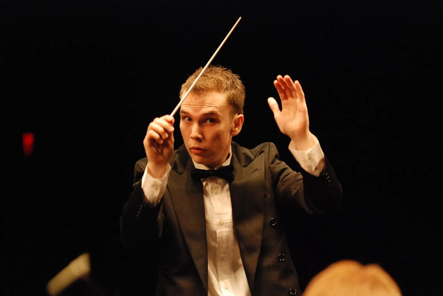 Estilo de liderança maestro regendo músicos como metáfora de gestão