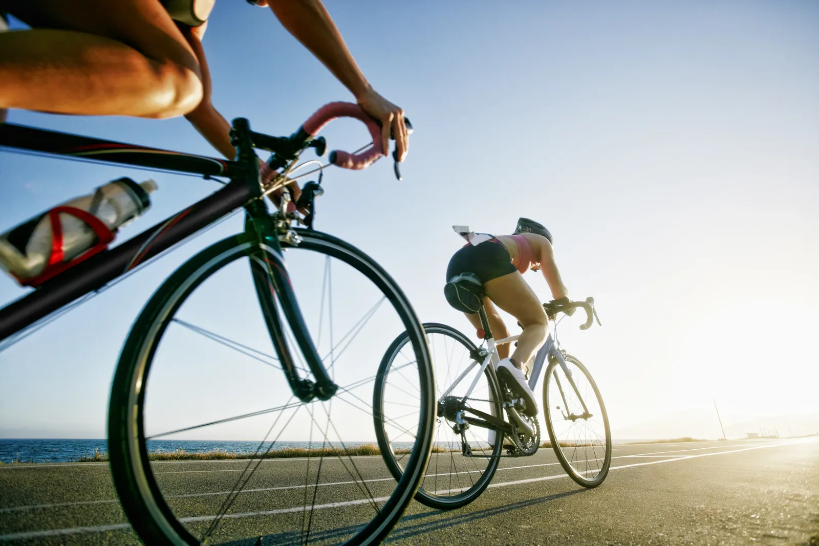 Ciclista em estrada ensolarada usando proteção solar, reforçando hábitos saudáveis do texto de inglês