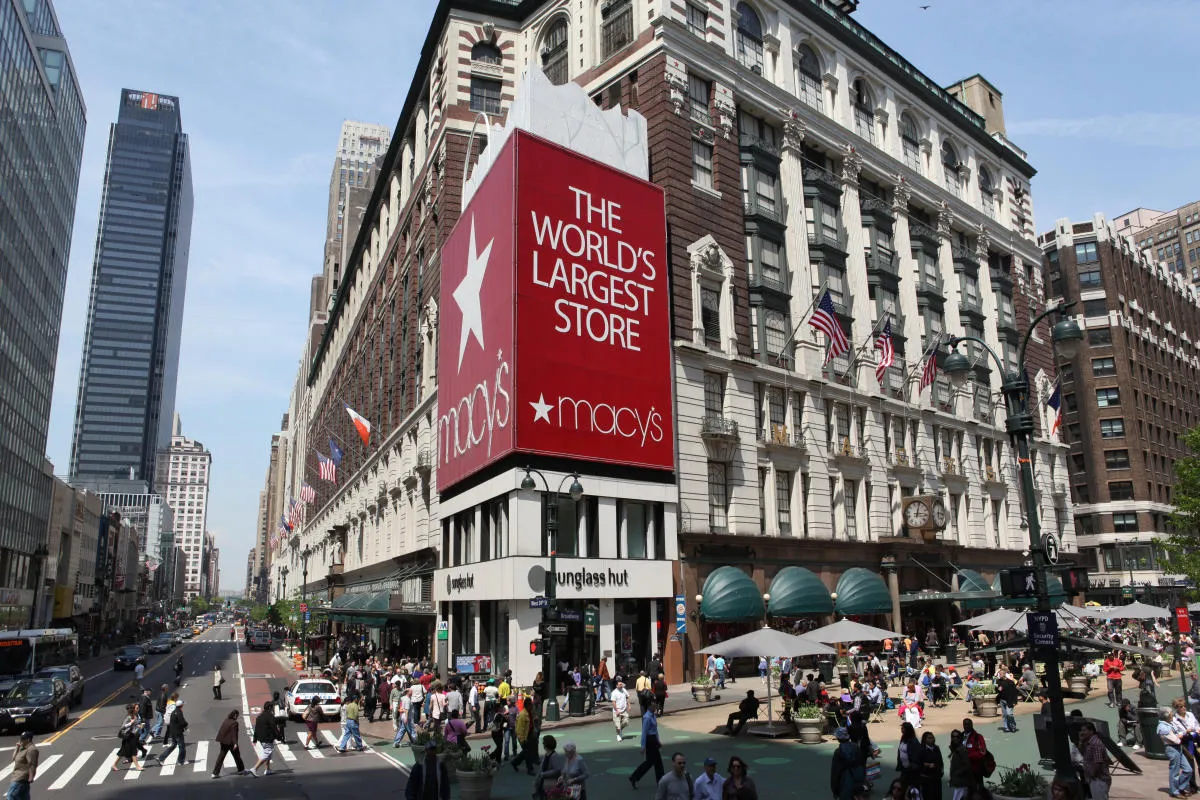 Fachada icônica da loja Macy's em Nova York, localizada na Herald Square, decorada com enfeites temáticos de Ação de Graças, simbolizando o início das compras de fim de ano e sua conexão com o famoso desfile anual