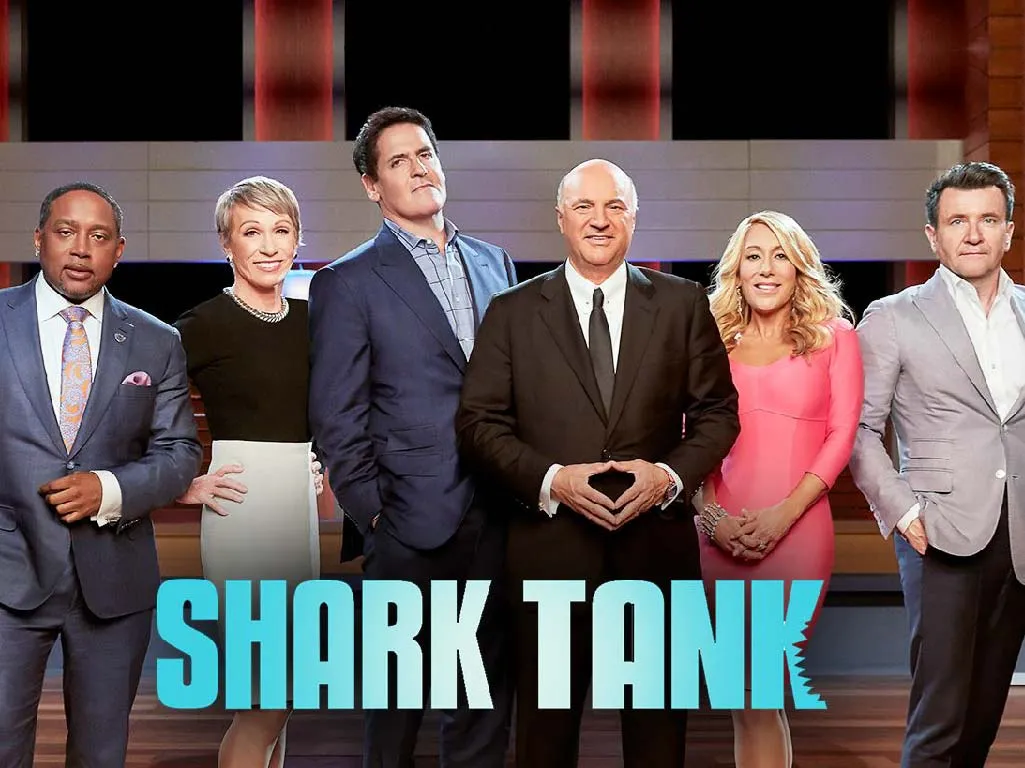 Empreendedor apresentando um pitch a investidores no estilo Shark Tank, treinando vocabulário de negociação em inglês.