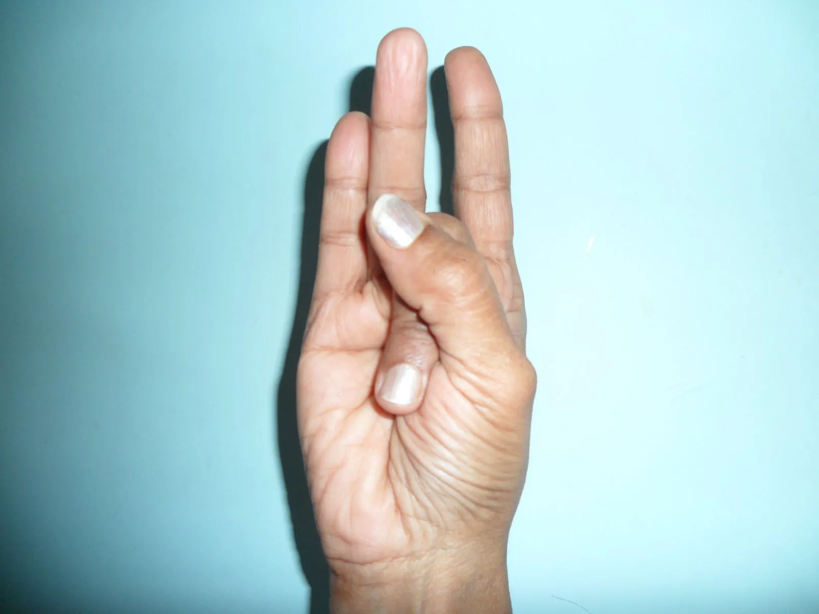 Mãos demonstrando o Shunya Mudra, associado ao alívio do ouvido e à audição