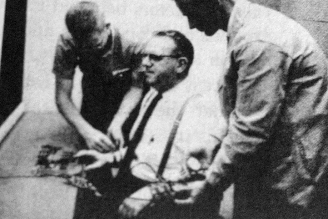 Participante aplica choque falso sob ordens de um pesquisador no experimento de Milgram