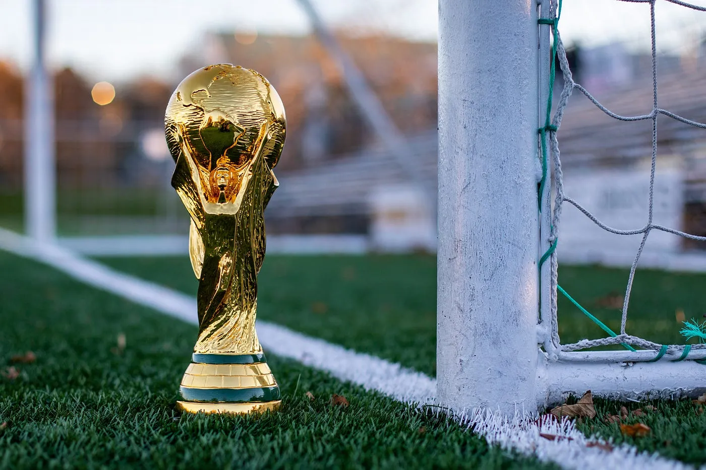 Taça de campeonato posicionada no centro do campo, representando conquistas no futebol profissional moderno