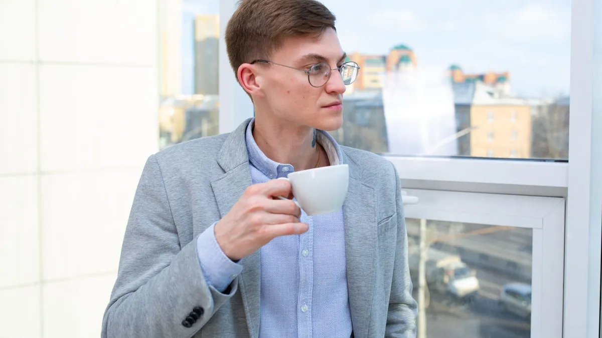 Pessoa descansando com um café perto da janela