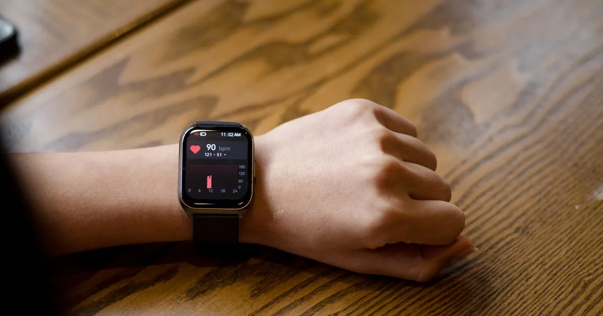 Smartwatch no pulso mostrando a frequência cardíaca em 90 bpm — o ritmo do coração que a coerência cardíaca treina