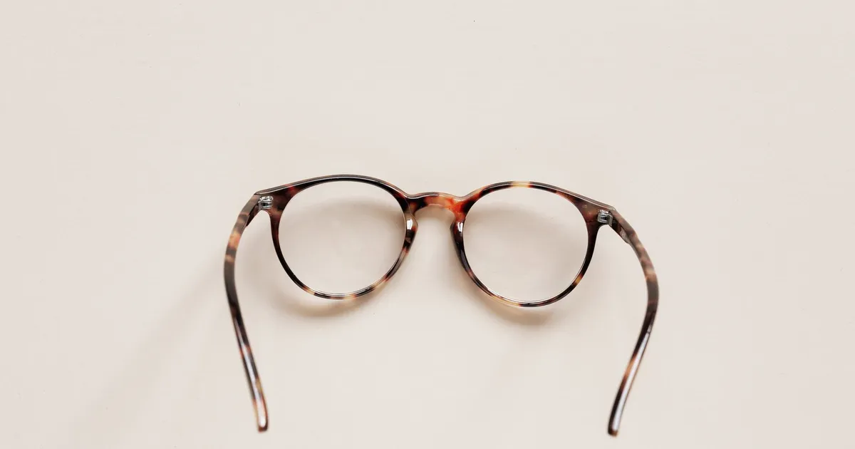 Óculos sobre uma mesa, ilustrando A Evolução das Lentes e Óculos: História, Avanços Tecnológicos e Curiosidades