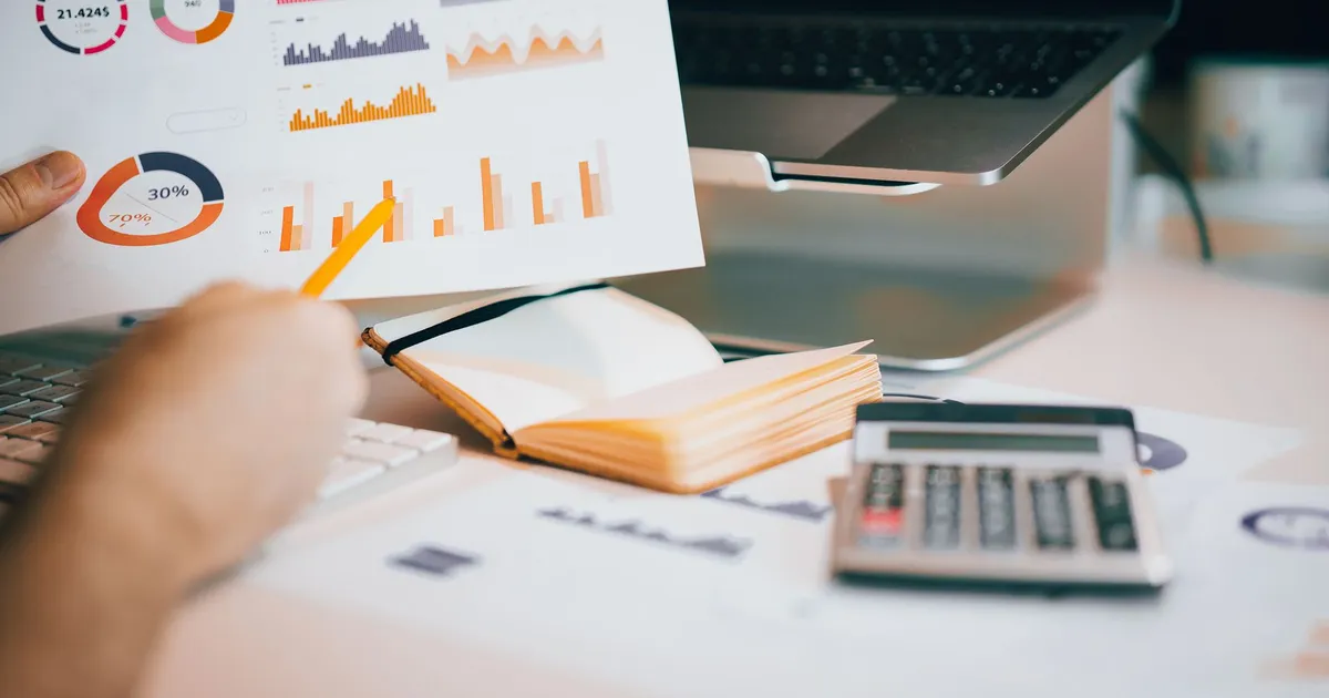 Gráficos financeiros sobre a mesa, ilustrando Índices Financeiros em Inglês (Financial Ratios)