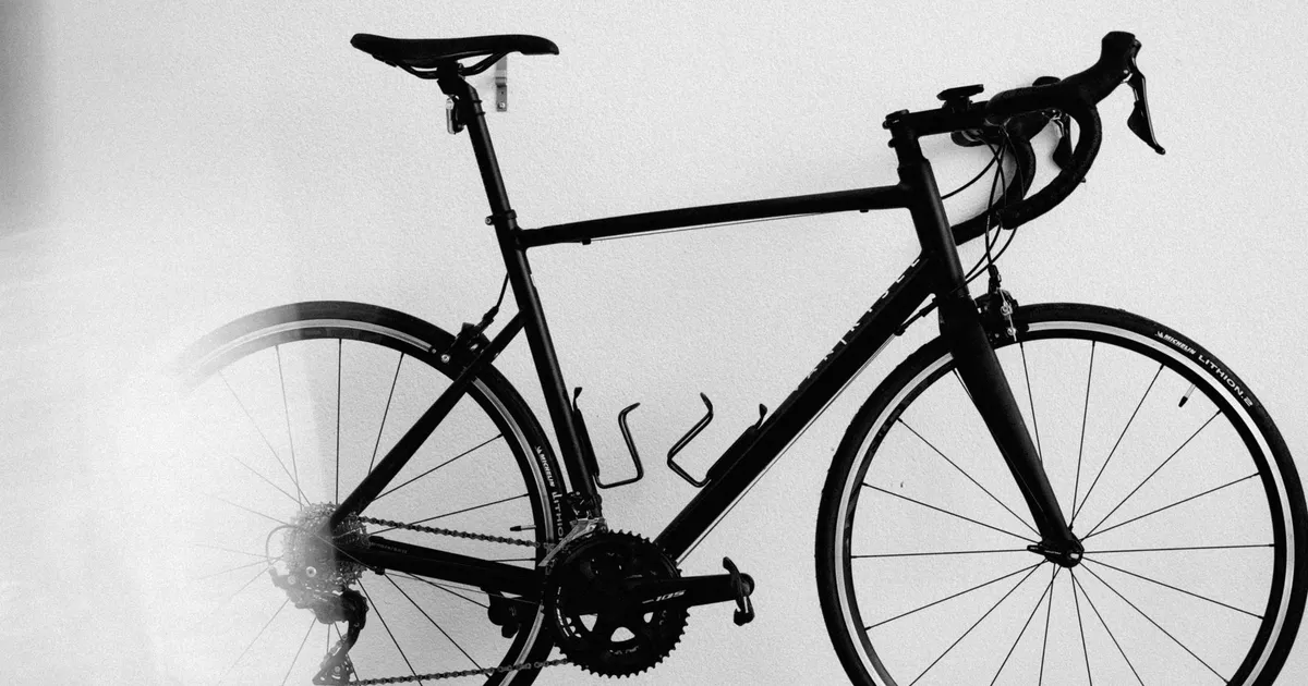 Ciclista pedalando em estrada, ilustrando Verbo \Should\ em Inglês: Dicas para Andar de Bicicleta