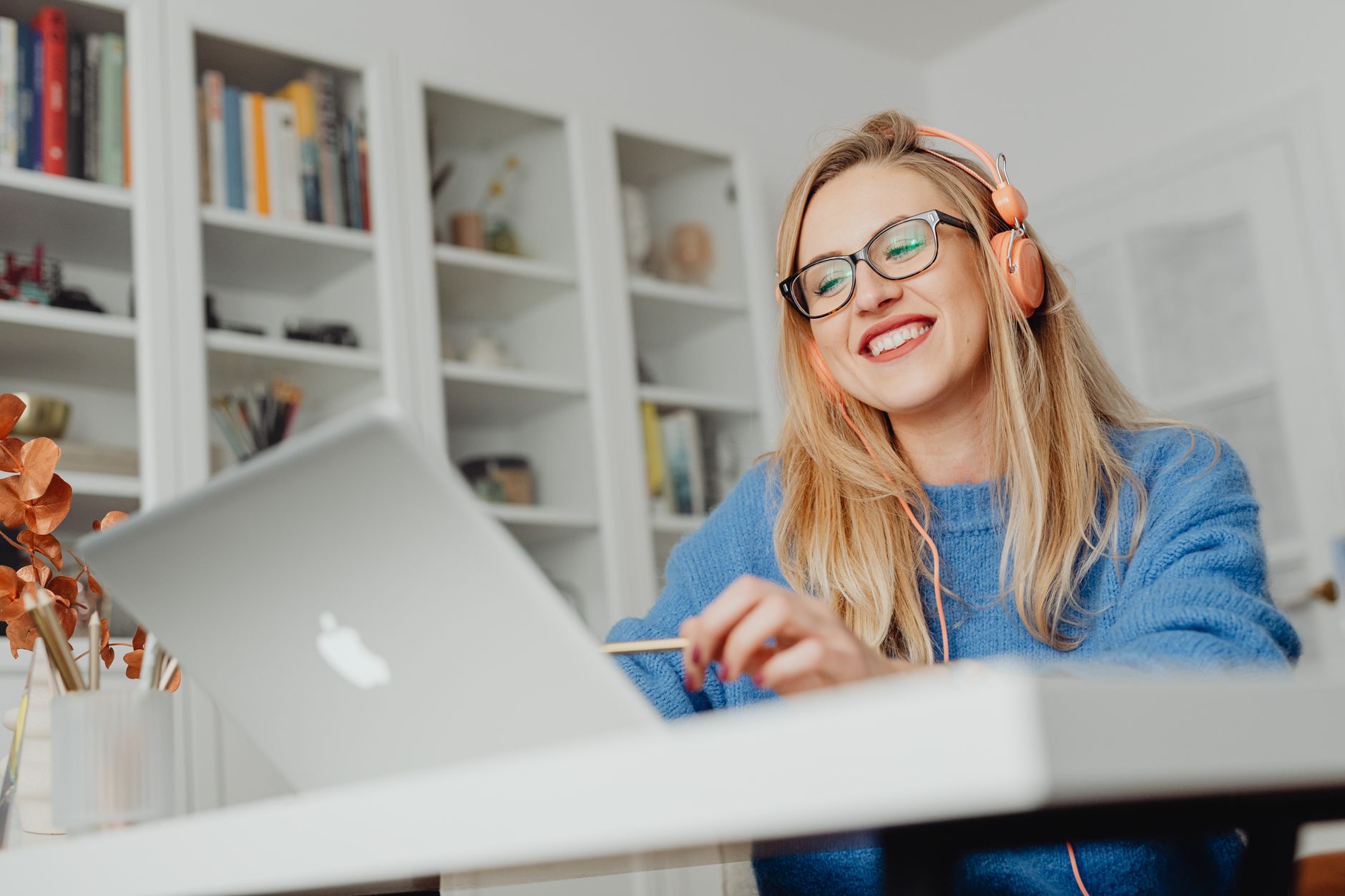 Estudante ouvindo notícias em inglês com fones de ouvido para treinar listening.
