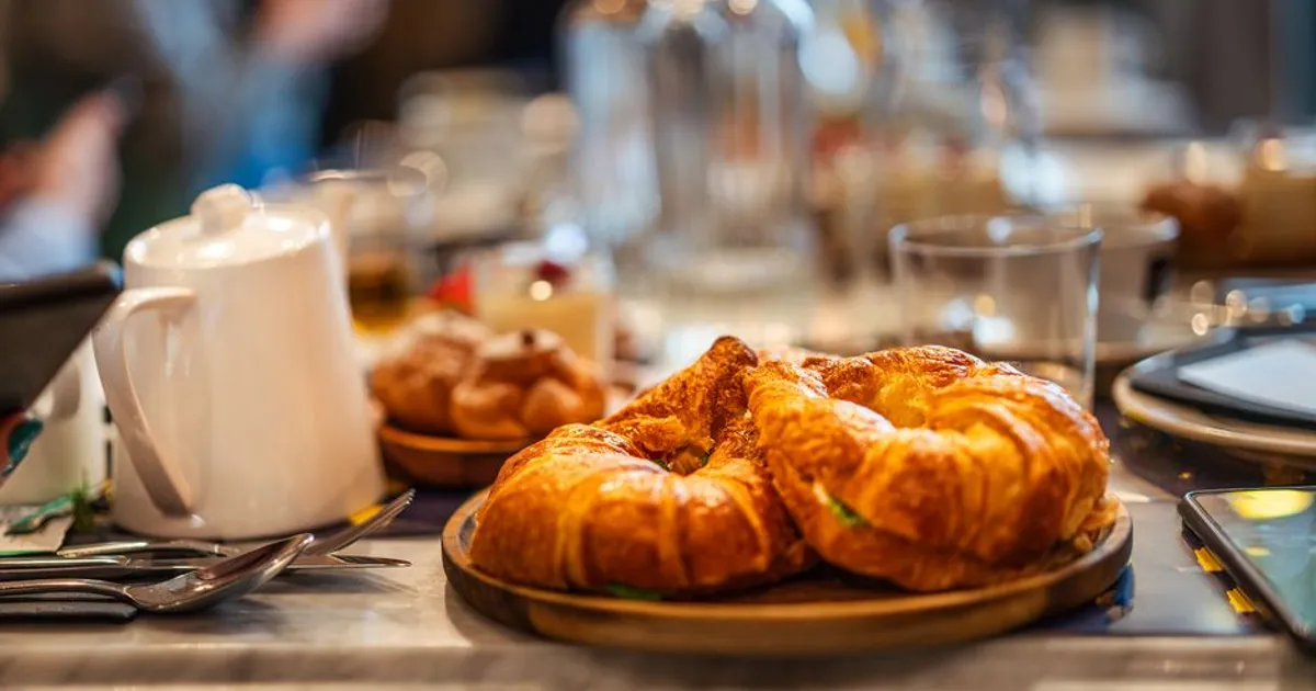 Croissants e café numa mesa de cafeteria — palavras francesas usadas no inglês, como croissant, café e menu