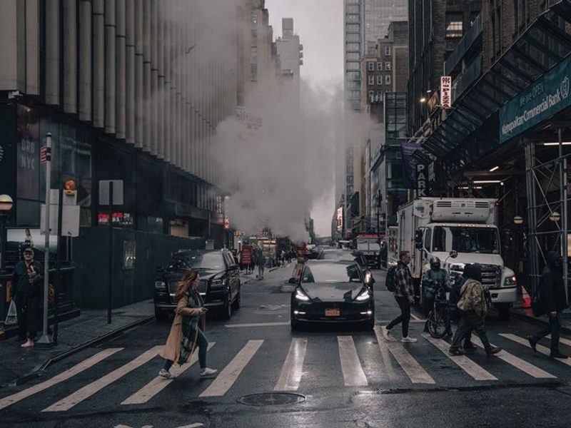 Rua vertical de Nova York com prédios altos e vapor saindo do chão