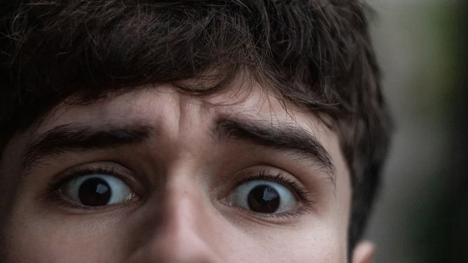 Rosto de um rapaz de olhos arregalados, incrédulo