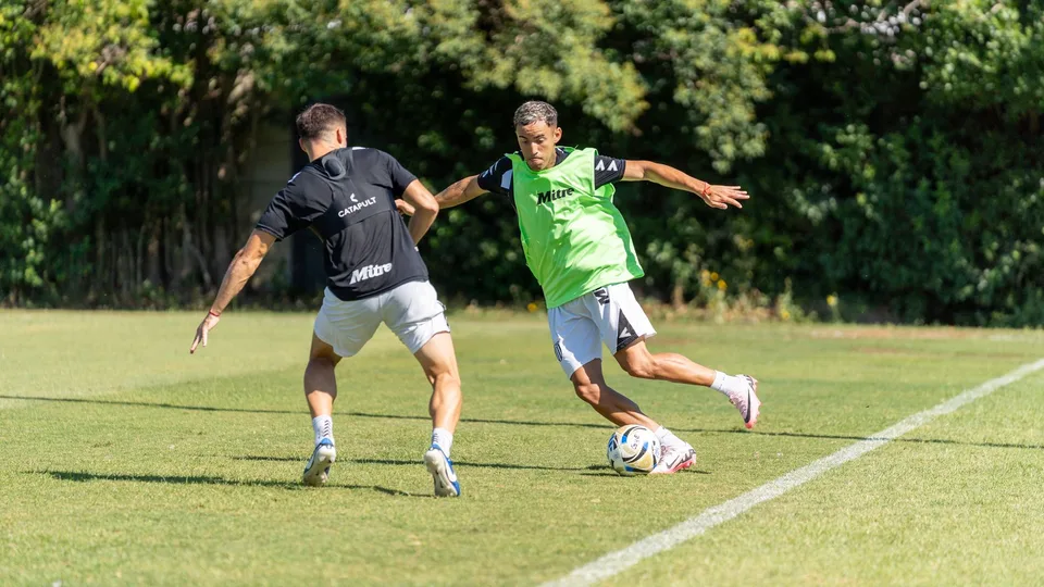 Dois jogadores disputando a bola num treino de futebol