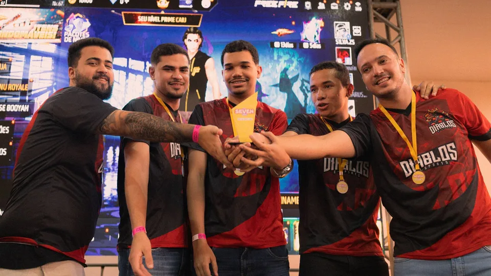 Time de esports comemorando com medalhas no palco