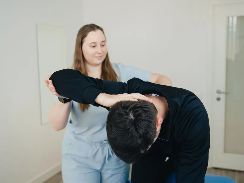 Fisioterapeuta conduzindo o alongamento de um paciente