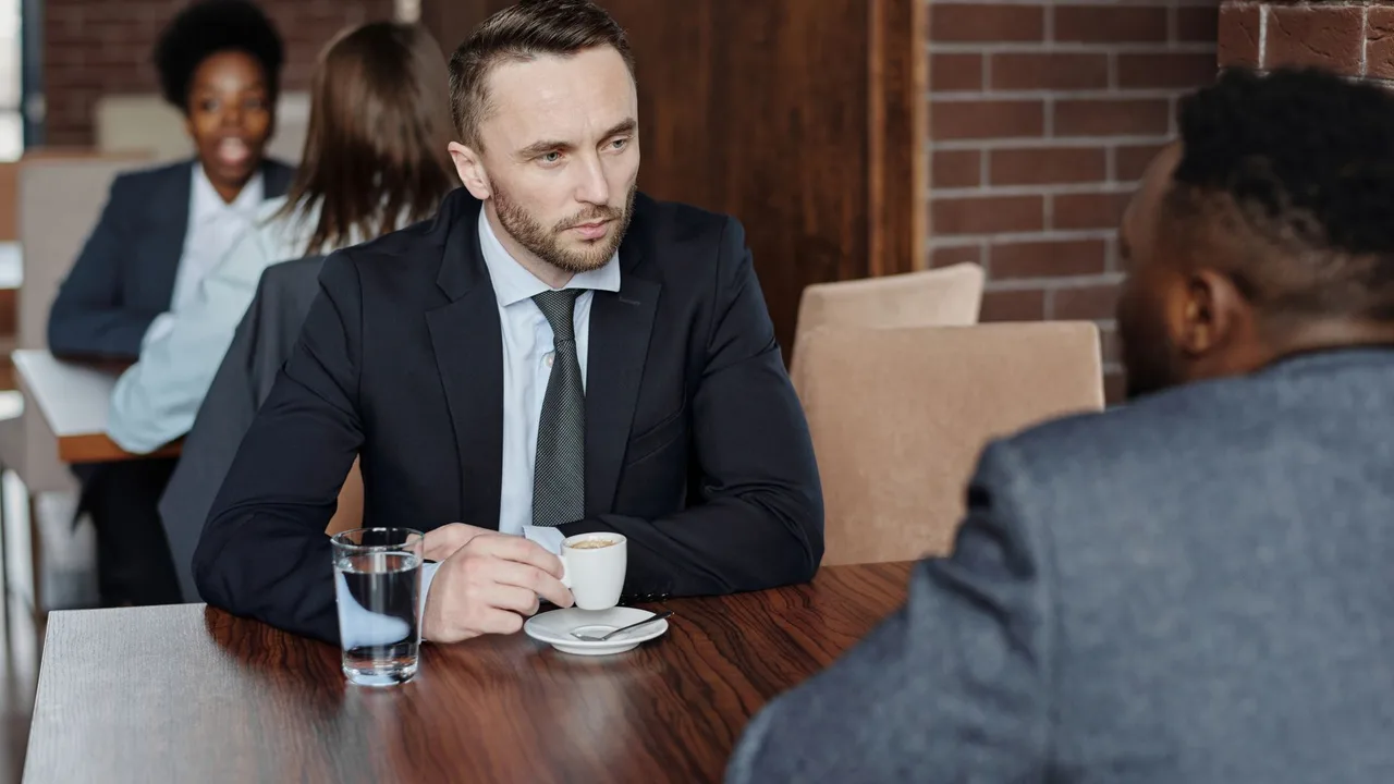 Duas pessoas em conversa séria à mesa